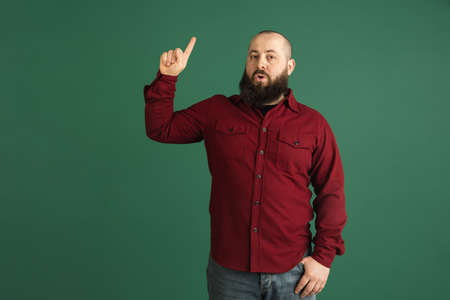 Handsome caucasian man portrait isolated on green studio background with copyspaceの写真素材