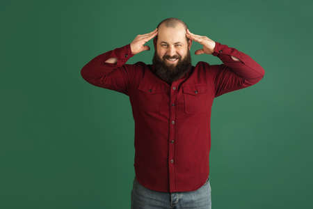 Handsome caucasian man portrait isolated on green studio background with copyspace