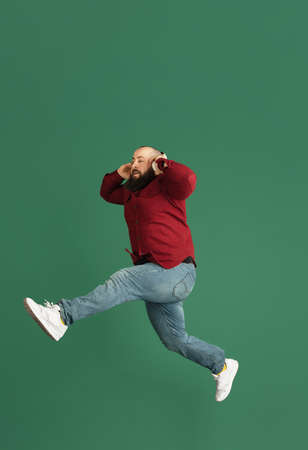 Handsome caucasian man portrait isolated on green studio background with copyspaceの写真素材