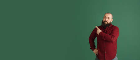 Handsome caucasian man portrait isolated on green studio background with copyspaceの写真素材