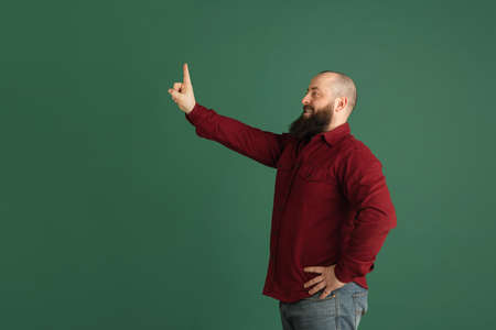 Handsome caucasian man portrait isolated on green studio background with copyspaceの写真素材