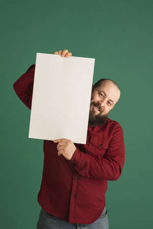 Handsome caucasian man portrait isolated on green studio background with copyspaceの写真素材