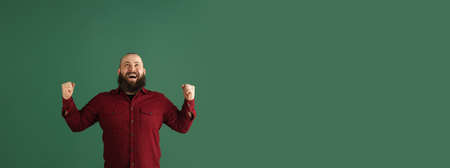 Handsome caucasian man portrait isolated on green studio background with copyspaceの写真素材