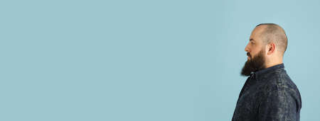 Handsome caucasian man portrait isolated on blue studio background with copyspaceの写真素材