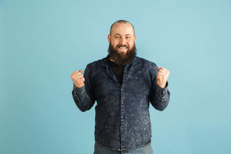 Handsome caucasian man portrait isolated on blue studio background with copyspaceの写真素材