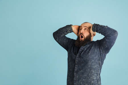 Handsome caucasian man portrait isolated on blue studio background with copyspaceの写真素材