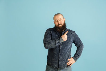 Handsome caucasian man portrait isolated on blue studio background with copyspaceの写真素材