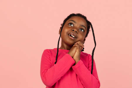 Handsome african little girl portrait isolated on pink studio background with copyspaceの写真素材