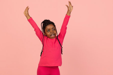 Handsome african little girl portrait isolated on pink studio background with copyspaceの写真素材