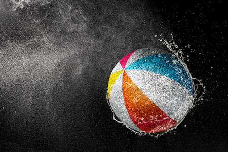 Volleyball ball flying in water drops and splashes isolated on black backgroundの写真素材
