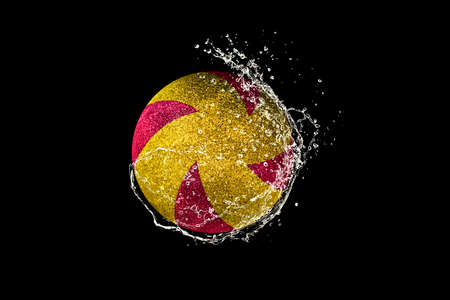 Volleyball ball flying in water drops and splashes isolated on black backgroundの写真素材