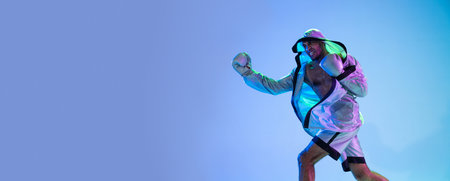 High-fashion styled man in white outfit pacticing box isolted over gradient background in neon light
