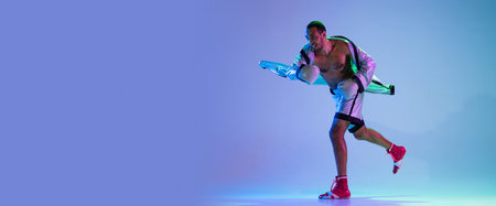 High-fashion styled man in white outfit pacticing box isolted over gradient background in neon light