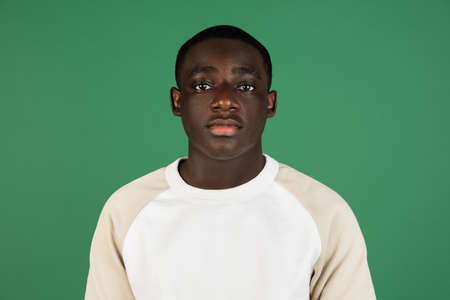 African mans portrait isolated on green studio background with copyspace
