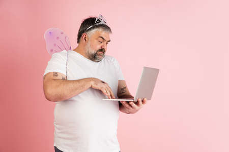 Handsome caucasian plus size male model isolated on coral pink studio background. Concept of...