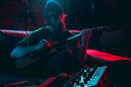 Close-up of musician performing in neon light. Concept of advertising, hobby, music, festival,...