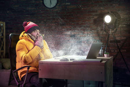 Young man in bright yellow puffy jacket meeting winter on virtual video call.