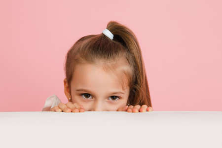 Pretty caucasian girl portrait isolated on pink studio background with copyspaceの写真素材