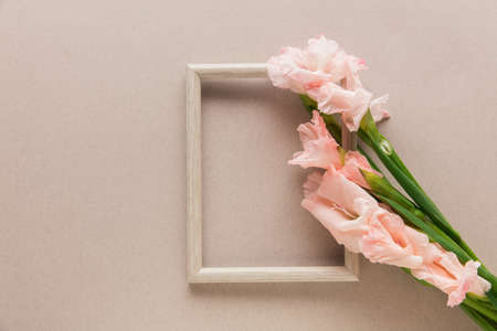 Flowers and frame on pastel background. Greeting card to Mother's, Parent's day. Beautiful floral mock up with copyspace. Celebrating, spring and summer mood, family concept. Feminine look.の写真素材