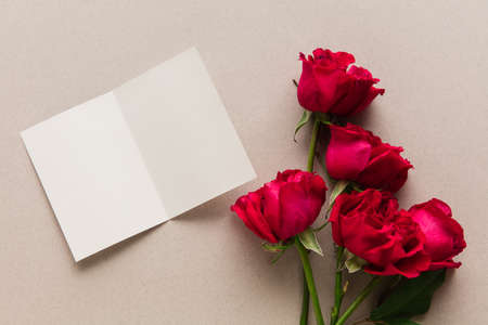 Roses and card on pastel background. Greeting card to Mother's, Parent's day. Beautiful floral mock up with copyspace. Celebrating, spring and summer mood, family concept. Feminine look.の写真素材