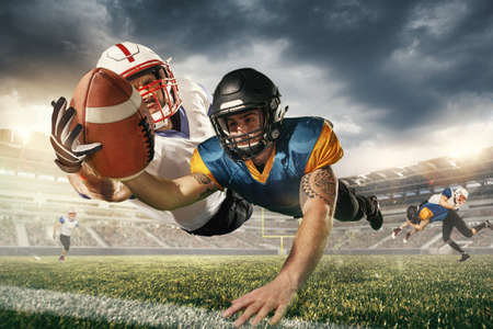 Winner. American football players in fight for goal at stadium in flashlights. Professional...