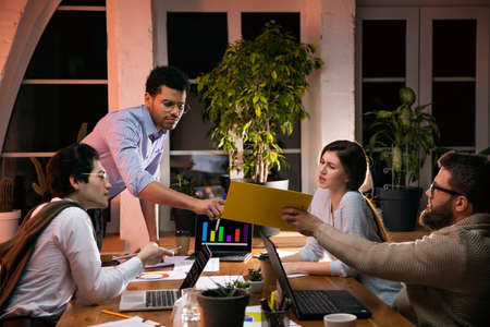 Colleagues working together in modern office using devices and gadgets during creative meeting