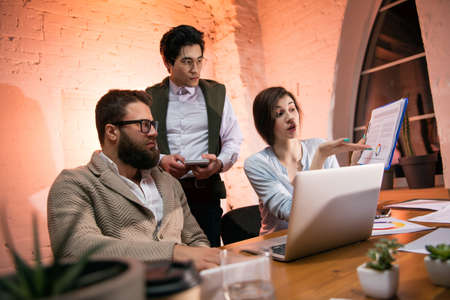 Colleagues working together in modern office using devices and gadgets during creative meetingの写真素材
