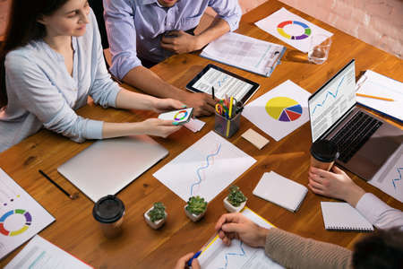 Colleagues working together in modern office using devices and gadgets during creative meeting