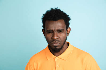 African mans portrait isolated over blue studio background with copyspaceの写真素材