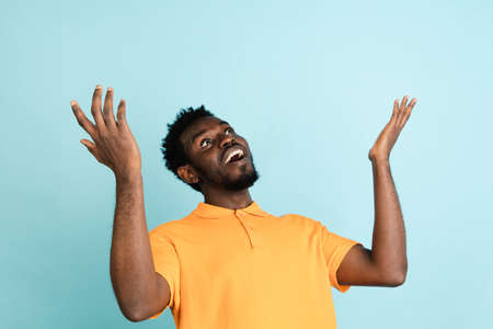 African mans portrait isolated over blue studio background with copyspace