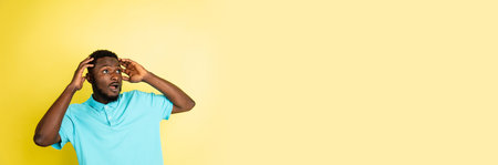 Portrait of young African man isolated over yellow studio background with copyspace.