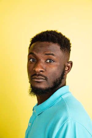 Portrait of young African man isolated over yellow studio background with copyspace.