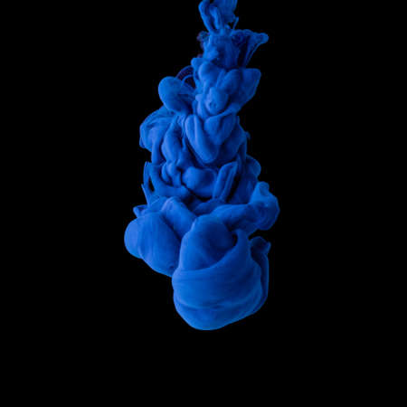 Explosion of colored, fluid and neoned liquids on black studio background with copyspaceの写真素材