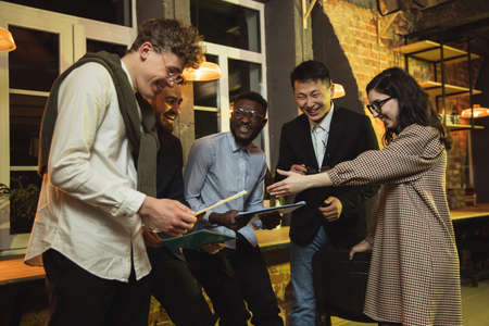 Colleagues working together in modern office using devices and gadgets during creative meetingの写真素材