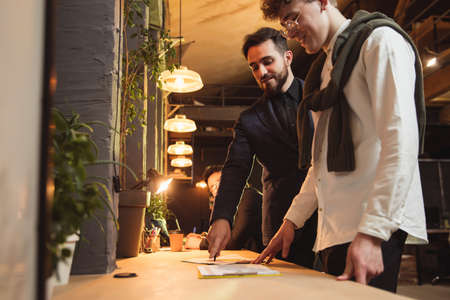 Colleagues working together in modern office using devices and gadgets during creative meetingの写真素材