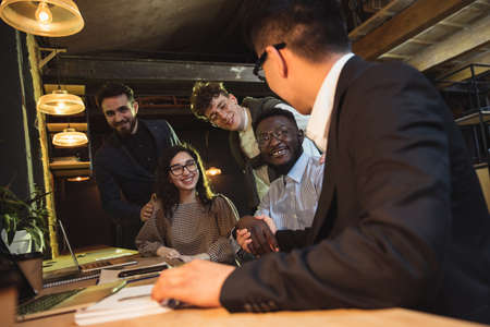 Colleagues working together in modern office using devices and gadgets during creative meetingの写真素材