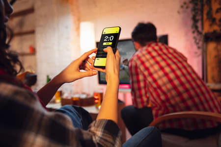 Group of friends watching TV, sport match together. Emotional man cheering for favourite team, celebrating successful betting. Concept of friendship, leisure activity, emotionsの写真素材