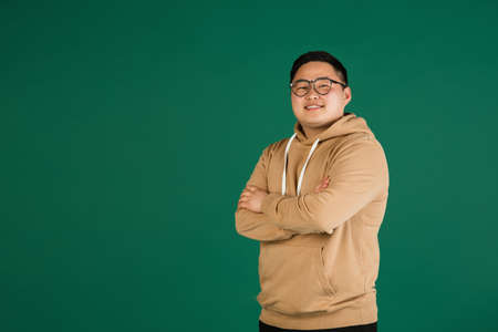 Asian mans portrait isolated over green studio background with copyspaceの写真素材