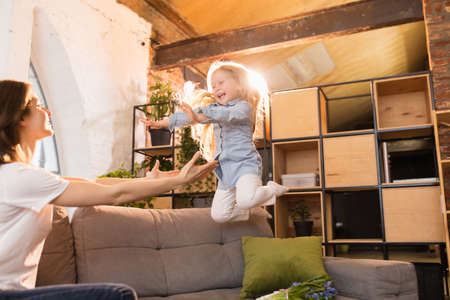 Family time. Mother and daughter having time together at home, look happy and sincere