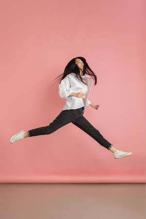 Asian young womans portrait on pink studio background. Concept of human emotions, facial expression,...