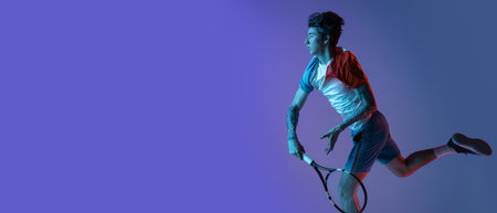 Young caucasian man playing tennis isolated on purple-blue studio background in neon, action and motion conceptの写真素材