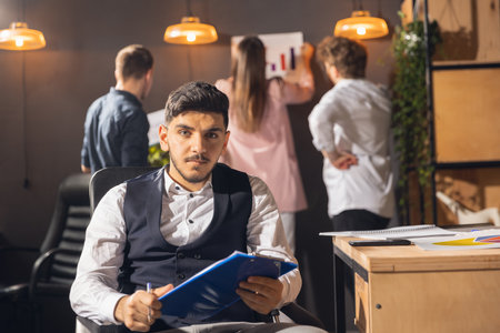 Colleagues working together in modern office using devices and gadgets during creative meetingの写真素材