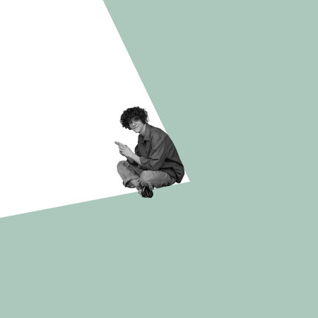 Modern design, contemporary art collage. Inspiration, idea, trendy urban magazine style. Young man sitting in white angle on pastel green backgroundの写真素材