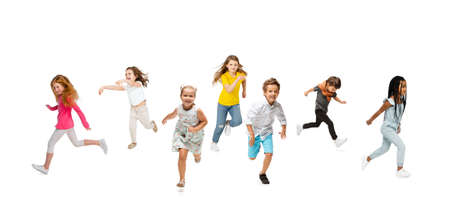 Group of elementary school kids or pupils running in colorful casual clothes on white studio background. Creative collage.の写真素材