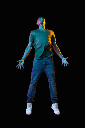 African-american young mans portrait on dark studio background in neon. Concept of human emotions,...