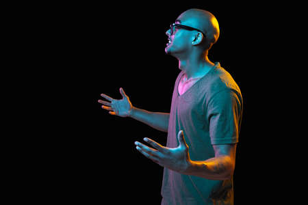 African-american young mans portrait on dark studio background in neon. Concept of human emotions,...