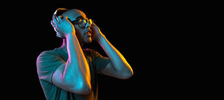 African-american young mans portrait on dark studio background in neon. Concept of human emotions,...