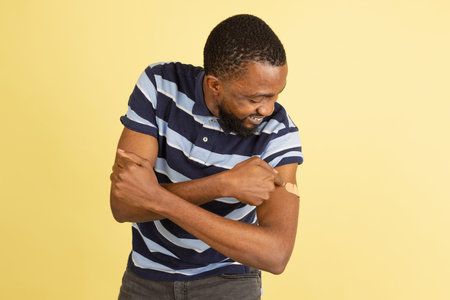 One African young man posing isolated over yellow studio background with copyspace for ad