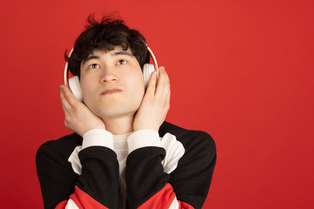 Asian mans portrait isolated over red studio background with copyspace