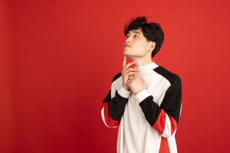 Asian mans portrait isolated over red studio background with copyspace